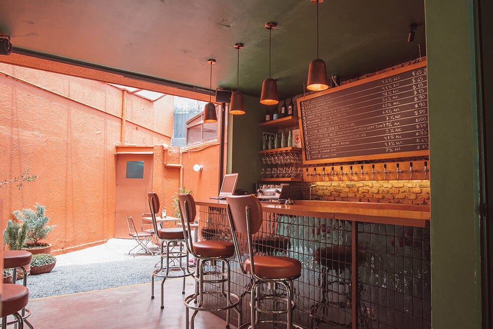 Mesas y barra del espacio Cerveza Zorra hogar de la creación de cerveza artesanal en Guadalajara de la mano de Paco y Jaime en colaboración con taller binario
